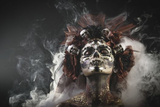 Santa Muerte Young Girl with Artistic Halloween Makeup and with Sculls in her Hair