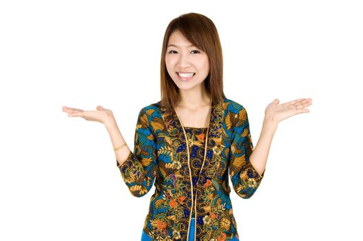 Southeast Asian girl with batik kebaya clothes holding hand showing something, standing isolated on white background.