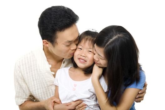 Asian family portrait on white background. Asian parents kissing daughter.