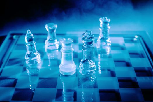 Blue light glass chess with some smoke in the background