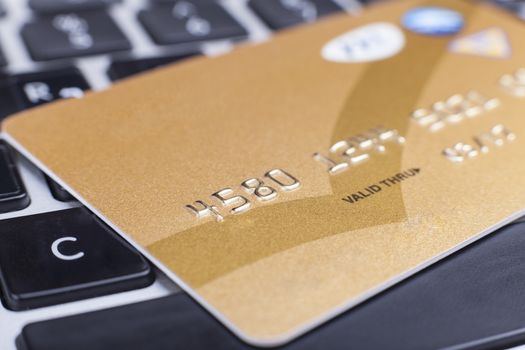 Golden Credit card close-up on computer keyboardwith numbers