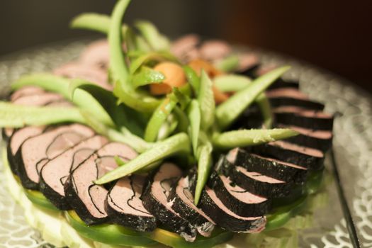 Sushi pile ornated with cucumbers and peppers on a plate