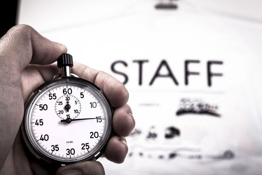 Silver vintage metalic chronometer in a hand with a white staff shirt in the background