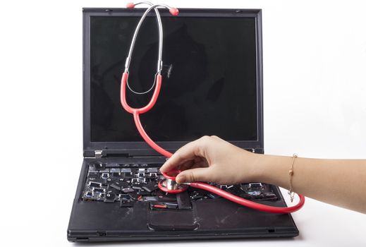 Hand examining broken laptop with red stethoscope isolated on white background