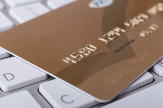 Golden Credit card close-up on computer keyboardwith numbers