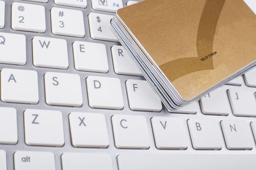 Credit cards stack on white and silber computer keyboard 