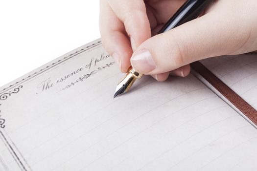 Female hand writing empty page in diary with fountain pen