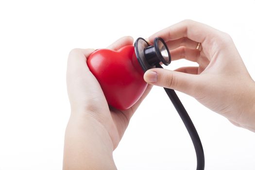 Red Heart in emale hand examined by stethoscope isolated on white