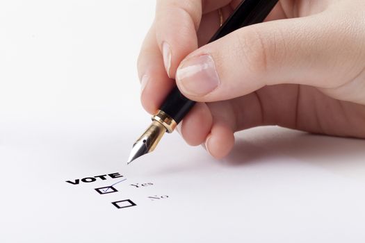 Woman hand voting yes in check-box with blue fountain pen in the air