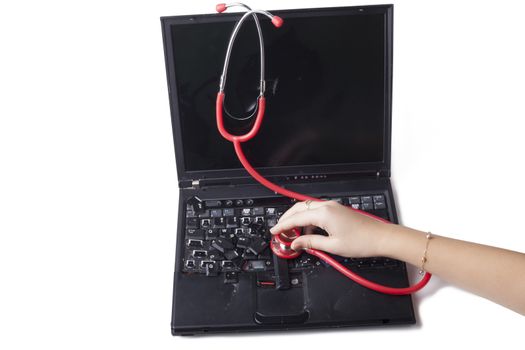 hand holding red stethoscope on broken laptop keyboard solated on white