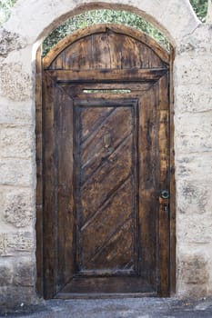 Old brown wood entrance door with white brick wall