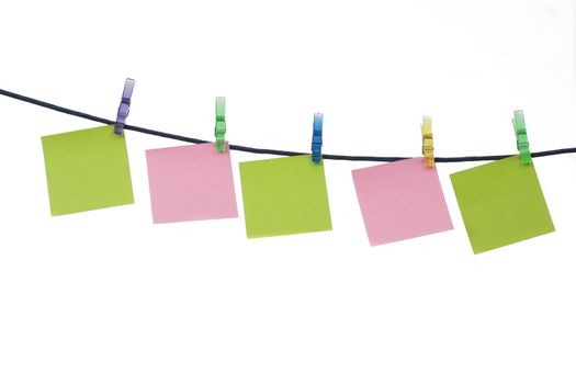 Coloured memos on string with clothespin isolated on white background