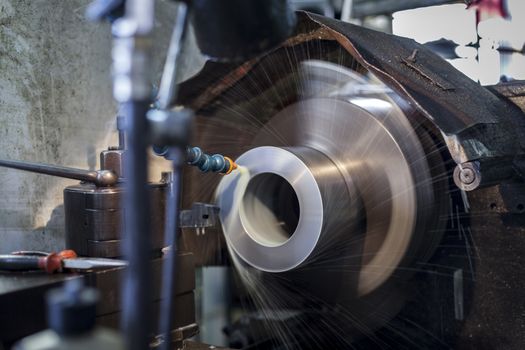 Metalworking machinery in action with cooling liquid spinning fast