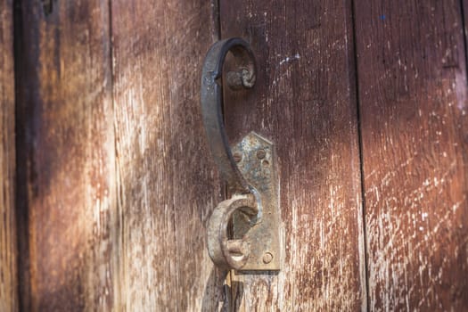 Old door rusty handle on old wood textured background
