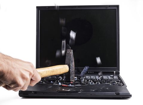Barking black laptop with hammer flying keys isolated on white background