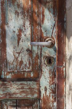Old door handle on wooden blue textured door