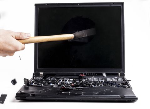 Barking black laptop with hammer flying keys isolated on white background