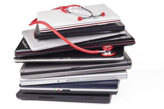 Huge laptop pile with a red stethoscope isolated on white