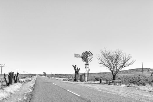 Monochrome view of a water-pumping windmill and picnic spot on road R48 between Phillipstown and De Aar in the Northern Cape Province