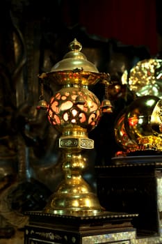 Gild lamp in a darkness of a buddhist Temple, Vietnam