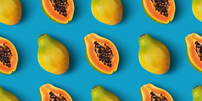 Papaya fruit seamless pattern on blue color background, flat lay, top view