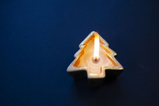 flat lay of burning candle in the shape of a Christmas tree
