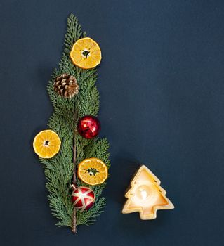 flat lay of christmas arrangement with candles  oranges  decorations on fir branch