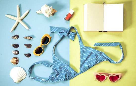 flat lay of beach holiday items: swimming suit,  sunglasses,  smartphone