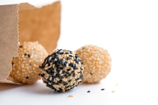 fried sesame dessert balls with paper bag on white background