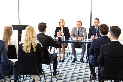 Business man from audience asking question at seminar