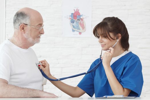 Doctor examining heartbeat of senior male patient