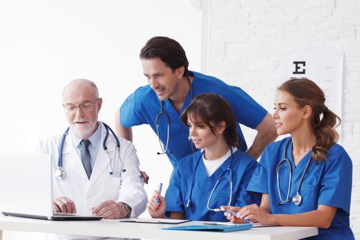 Medical doctors team using computer isolated on white