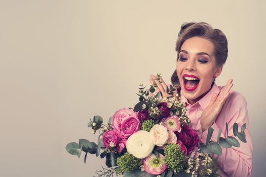 Woman surprised with bunch of flowers, funny emotional expression