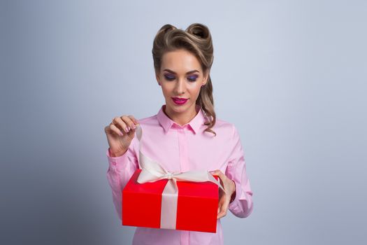 Happy beautiful funny woman open red gift box with white ribbon