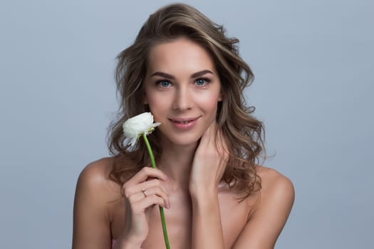 Portrait of attractive caucasian woman blond holding white rose flower