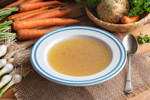 Chicken bone broth with vegetables on a table