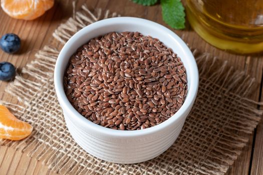 Flax seeds in a bowl, with oil in the background