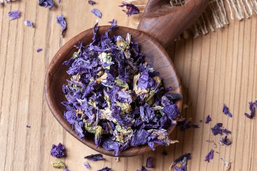 Dried flowers of malva sylvestris mauritiana, a variety of mallow, on a spoon