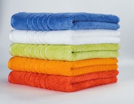 Pile of Multicolored towels on a white background