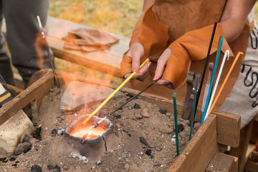 Glass blower's hands. Fragment. To blow glass beads by means of fire.