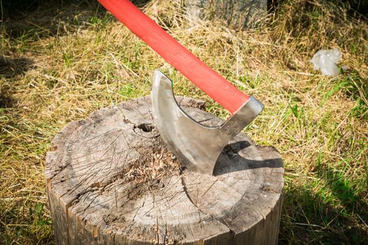 the big axe cuts a tree on a grass