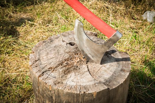 the big axe cuts a tree on a grass