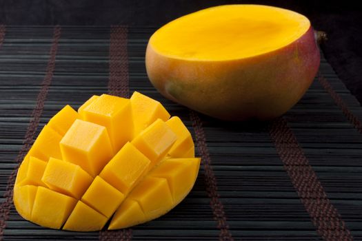 Mango slice cut to cubes close-up  on dark background