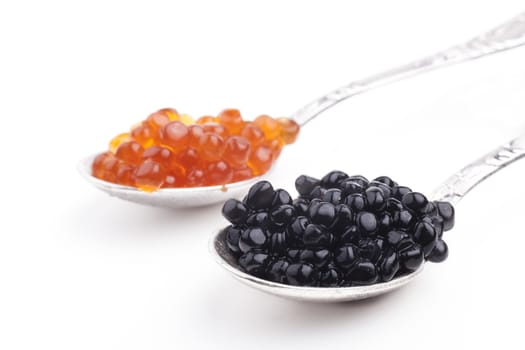 Red and Black caviar beads on silver spoon close-up isolated on white background
