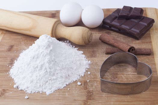 Baking ingredients an ustensils on brown wod board