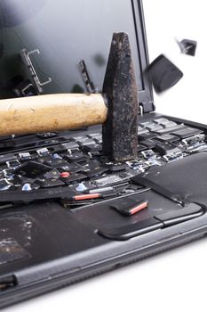 Smashing laptop with black hammer on white background