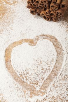heart shape flour on brown wood cutting board