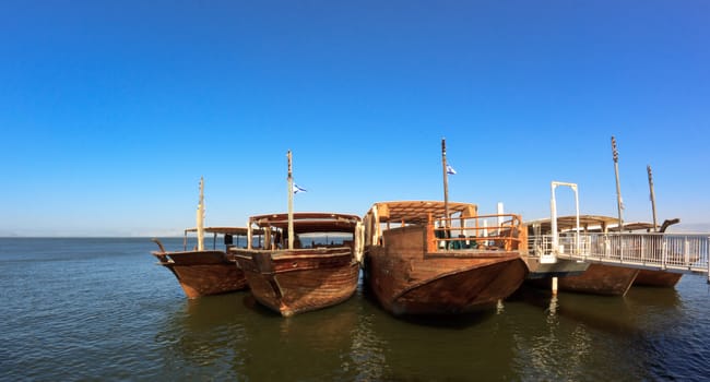 old wood boats on the galileean sea with blue sky