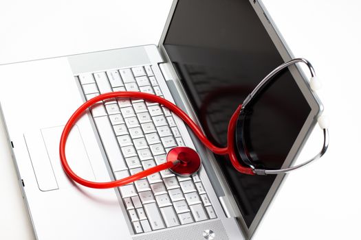 silver laptop diagnosis with red stethoscope isolated on white background
