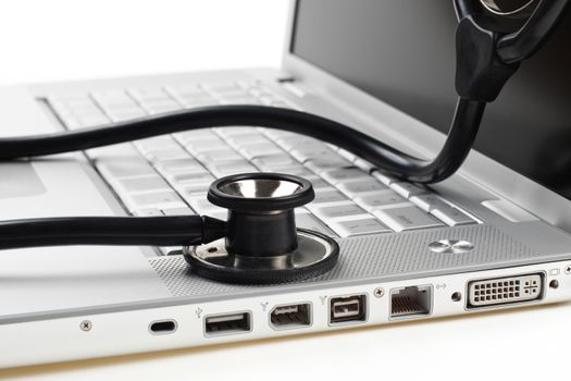 silver laptop diagnosis with black stethoscope crop closeup isolated on white background